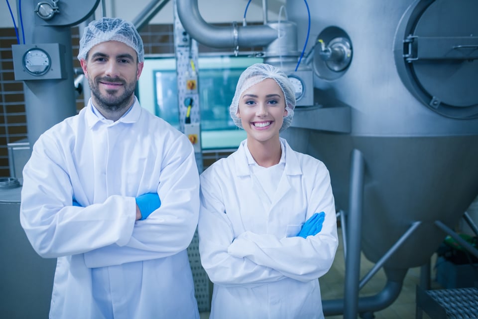 Food technicians smiling at camera in a food processing plant-1