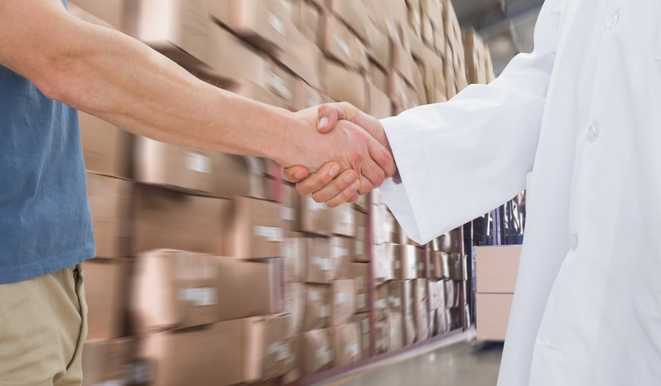 Mid section of a doctor and patient shaking hands against forklift machine in warehouse